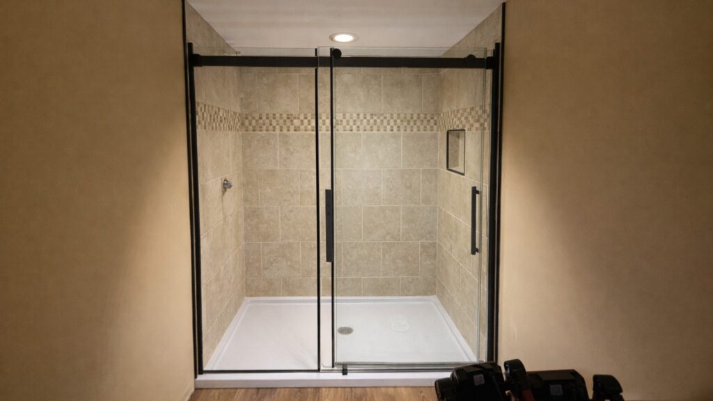 Walk-in shower renovation with beige wall tile and framed glass enclosure