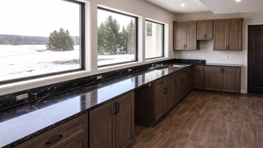 Kitchen renovation with dark stone countertops and warm wood cabinetry