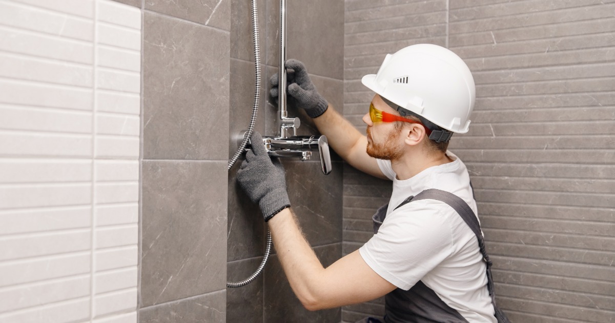Skilled trades working on a bathroom renovation including tile, plumbing, and finish installation