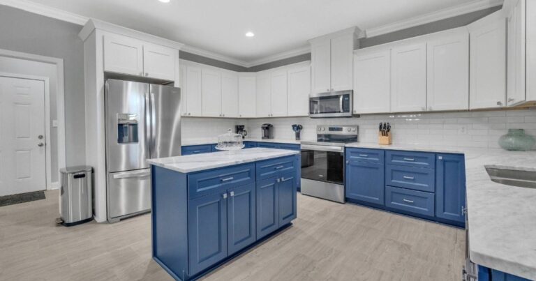 Finished kitchen renovation with custom cabinetry, updated countertops, tile backsplash, and layered lighting