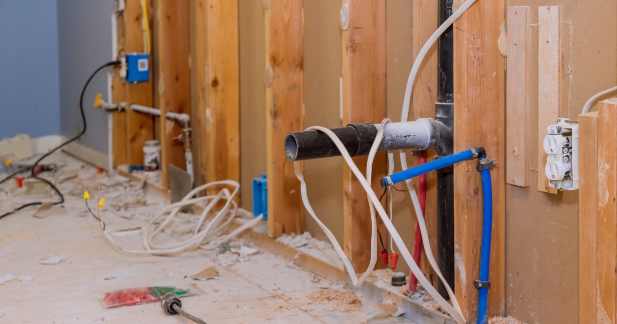 Kitchen renovation exposing older wiring, plumbing, and hidden construction conditions behind walls