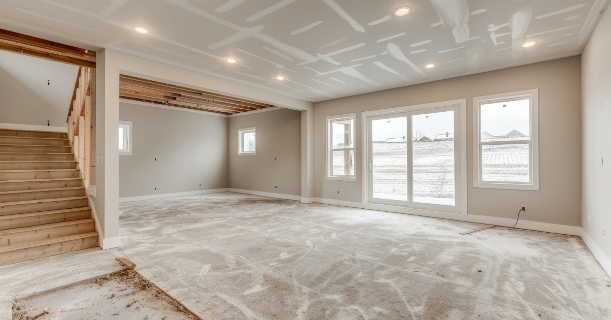 Basement renovation showing recessed lighting, finished ceiling details, and mechanical coordination around ductwork