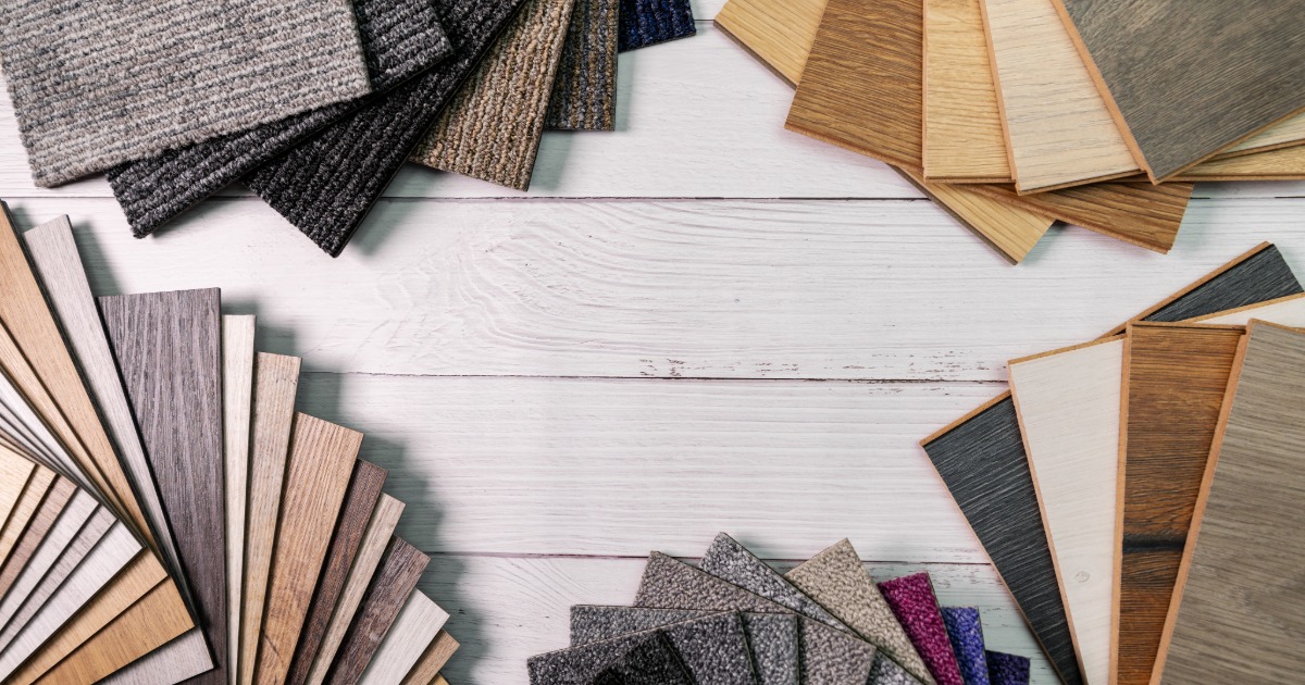 Basement renovation material samples showing flooring, trim, paint, and cabinetry options for a lower-level space